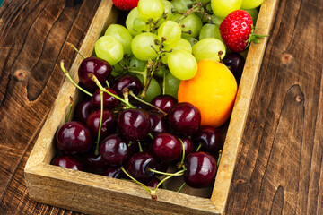 Fruits and berries in plate on table.