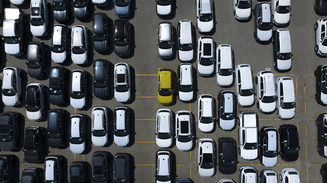 Aerial view of neatly arranged cars in a parking lot, a vibrant yellow car stands out amidst the monochromatic sea, Fremantle, Western Australia, Australia.