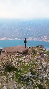 Man on top of Mount Vrmac near Bay of Kotor, Montenegro - drone view.