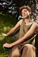 Stylish young man enjoying a sunny day in a vibrant green park during summer