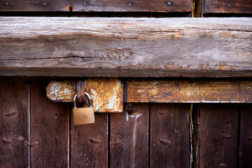 Rusty Lock Securing A Weathered Wooden Gate in Rustic Style