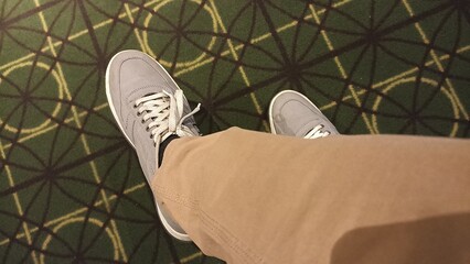 grey shoes over green carpetGrey shoes and tan pants on green patterned carpet, perfect for fashion...