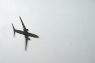 Shadow of a flying airplane on a white background. Concept of traveling