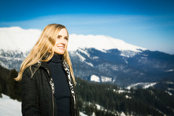 Portrait of young smiling girl travel in mountains alone. Winter adventure, woman in warm clothes...