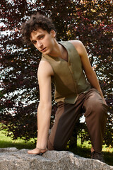 Stylish young man enjoys a sunny day in a green park with a relaxed vibe