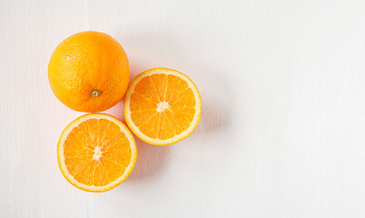 Top view of Halved orange fruit on white wooden background