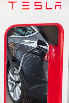 Berlin, Germany 09-17-2020 A black Tesla electric vehicle charges in one of the car manufacturer's public supercharger stations set up in the German capital.