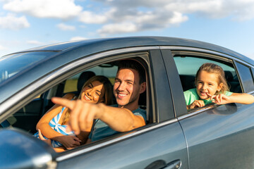 The family is sitting in the car, stepfather is showing his stepdaughter and his wife their...