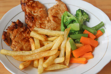 Grilled Chicken Steak with French Fries and Steamed Vegetables on a Plate