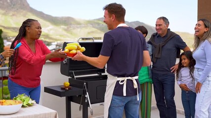 Happy multi generational family having fun cooking together barbecue dinner at house rooftop during summer time - Multiracial people, friendship and food concept - Powered by Adobe