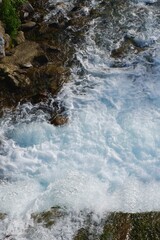 Clear blue water rushes over rocky terrain