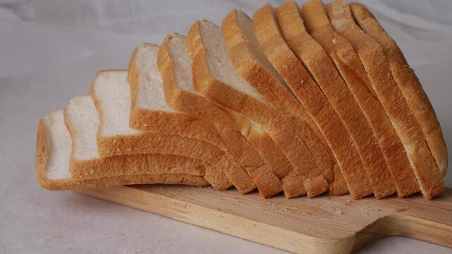 Toasted white bread loaf sliced on white background.