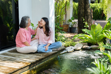 Daughter and elderly mother share a heartfelt moment together, strengthening their family bond....