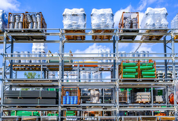 Bright and organized construction supplies stored on shelves under clear blue sky at a busy...