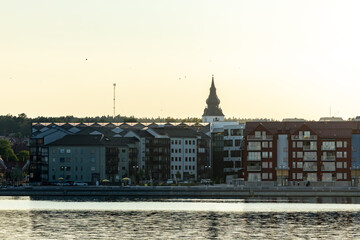 Fototapeta premium Hudikskvall, Sweden JA sunset skyline silhouetted view of the city and the Baltic Sea seafront.