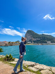 Young blonde woman viewing of the Rock of Gibraltar and the nearby runway with the sea and...