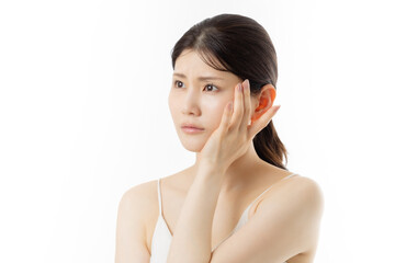 肌の悩みを気にする若い女性の表情（白背景）