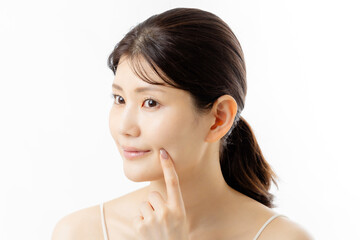 肌の悩みを気にする若い女性の表情（白背景）