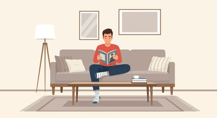 Young Man Relaxes At Home Enjoying A Good Book On A Sofa In The Living Room