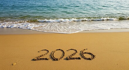Year 2026 written in sand on a beach with ocean waves, symbolizing future hopes, dreams, and vacation plans.