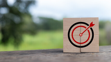 Wooden blocks with bullseye target and arrow symbolizing business goal, focus, achievement,...