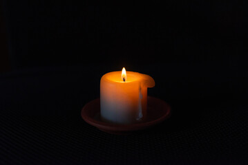A burning candle in the darkness. Selective focus,black background.