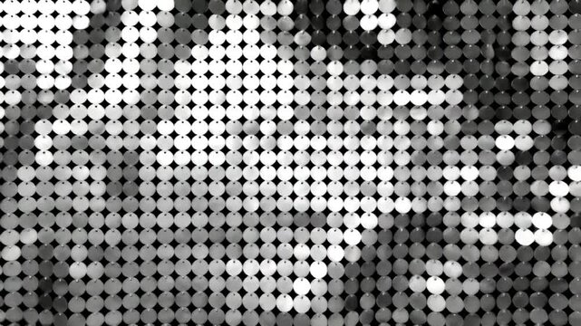 Shimmering kinetic wall of silver reflective discs creating a sparkling abstract background