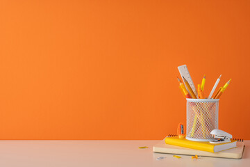 A brightly colored workspace setup with stationery in an organized and minimal style. Featuring vibrant orange tones and study essentials to inspire a creative and productive learning environment