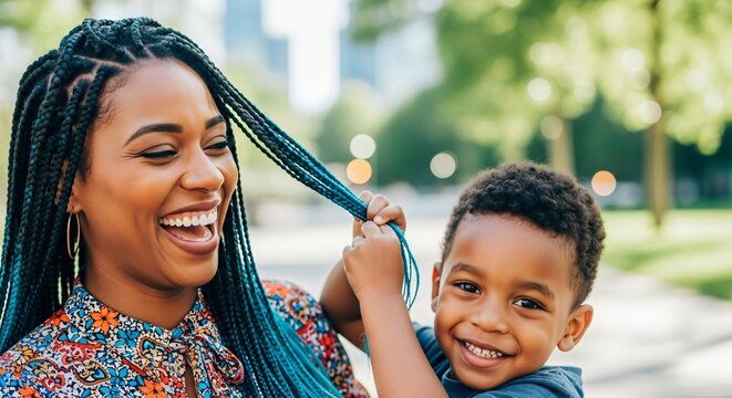 Mother's Day or family lifestyle photo of a mom and her little boy laughing while he touches her braided hair. Perfect for parenting blogs, family ads, and healthcare.