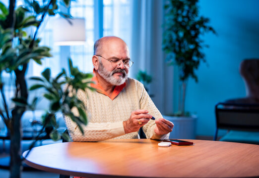 Concerned Indian senior checks sugar level and calls to share bad news about health - Powered by Adobe