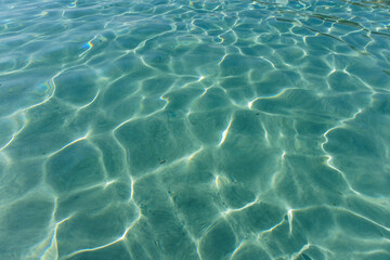 Blue water surface with sun reflections. Background and texture for design.