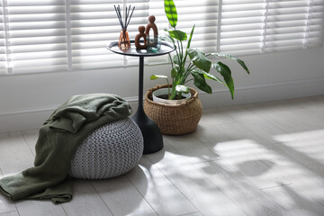 Stylish knitted pouf with plaid and home decor indoors