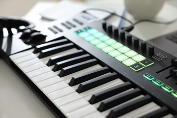 MIDI keyboard on white wooden table, closeup