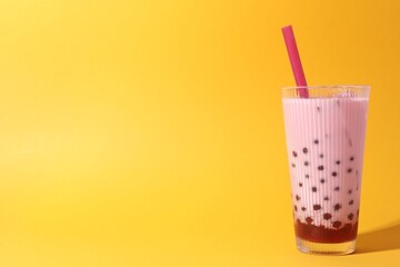 Tasty milk bubble tea in glass on orange background, space for text