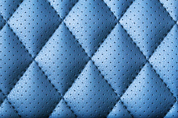 Obraz premium Blue leather texture pattern. Quilted textile material with stitching. Detailed square upholstery background. Soft surface with perforation. Elegant abstract fabric design. Interior decor texture.