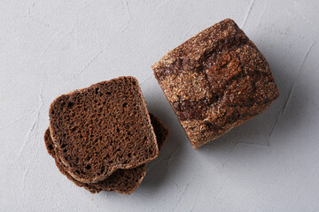 Pieces of fresh rye bread on light grey textured table, flat lay