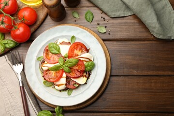 Tasty salad Caprese served with balsamic vinegar on wooden table, flat lay. Space for text