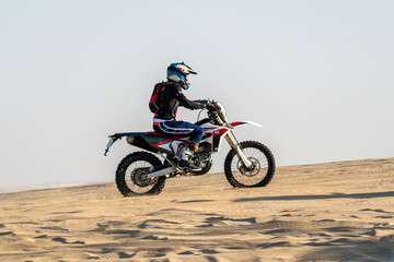 Obraz premium Motorcyclist on a cross-country motorcycle go fast at desert
