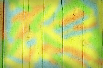 Multi colors paint on wooden plank.