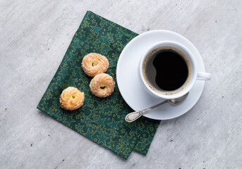 Typical brazilian sugar covered biscuit with coffee over wooden table