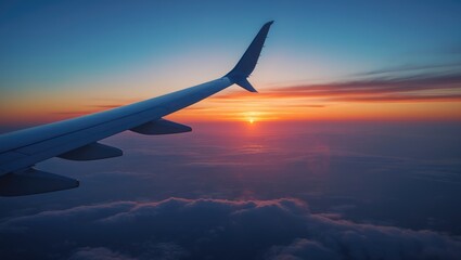 Naklejka premium Aircraft wing with sunset view from above the clouds during evening or morning.