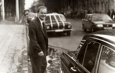 Vintage portrait of young man groom before wedding near car decorated with wedding decorations.