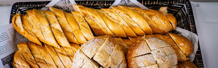 Fresh fragrant breads on the table. Bakery food concept panorama or wide banner photo background