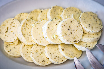 Festa cheese slices, feta garlic, herbs and spices background. Side view, selective focus.