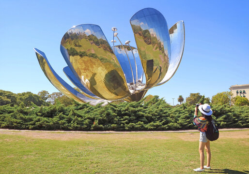 Female Visitor Shooting Photos of The Floralis Generica, a flower sculpture made of steel and aluminum, located on the Plaza de las Naciones Unidas in Buenos Aires, Argentina, South America
