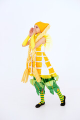 Call to action. Sale. Cheerful girl having fun, dancing and laughing on light background in yellow corn costume with funny facial expression in empty space. vertical.