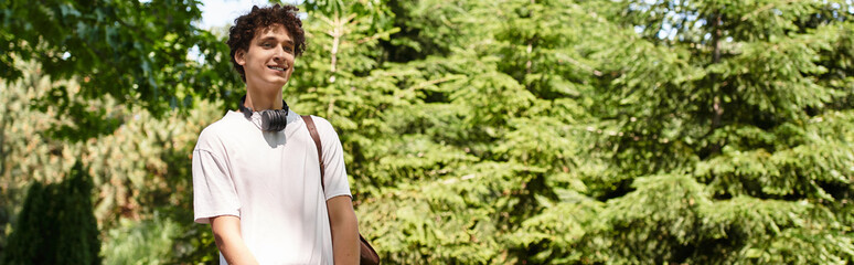 Young man enjoys a sunny day in a green park while wearing a casual outfit