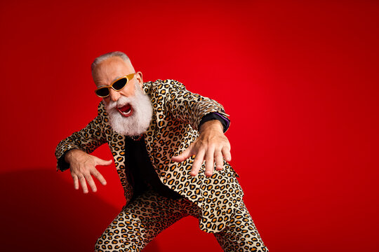Seniors in striking leopard print suits showcase lively energy on vibrant red backgrounds for retro, stylish, party themed stock images.