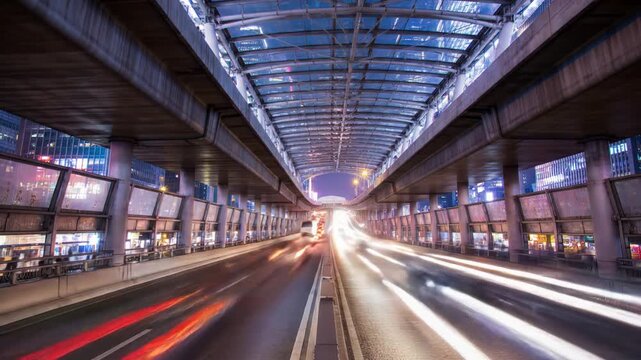A long exposure shot of a highway underpass at night, showing streaks of light from passing vehicles.