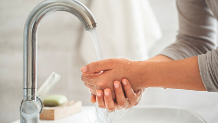 Woman washing her hands in the bathroom